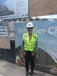 Woman in construction vest and hardhat on site