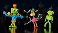 Left to right: a tall multicolored robot with an upside-down hat and balls rolling on its arms; a pink robot with a triangular body and tentacles for hair and arms; a green robot with a studded head