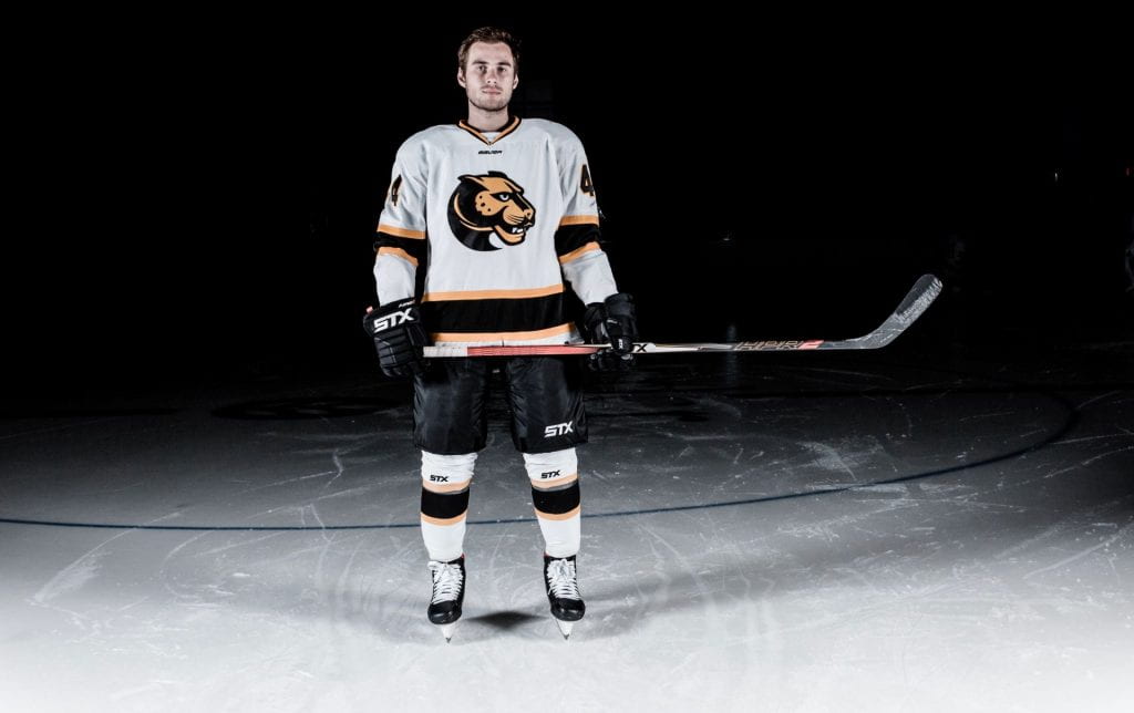 man in hockey uniform standing on ice