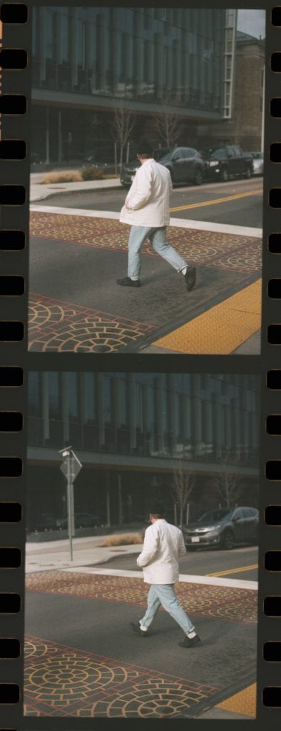 man walking across street